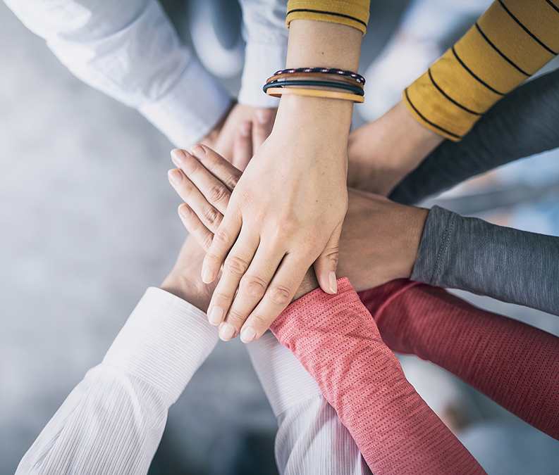 Close up top view of young business people putting their hands together. Stack of hands. Unity and teamwork concept.